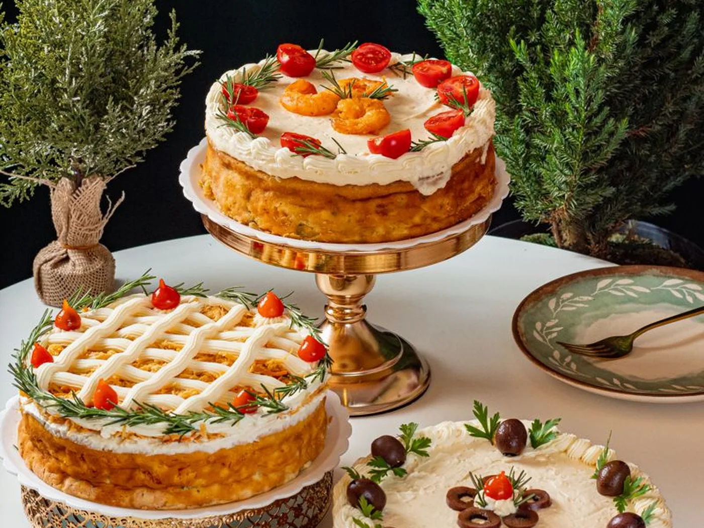 Mesa de Natal da Rôof com quiches e sobremesas em pedestais dourados