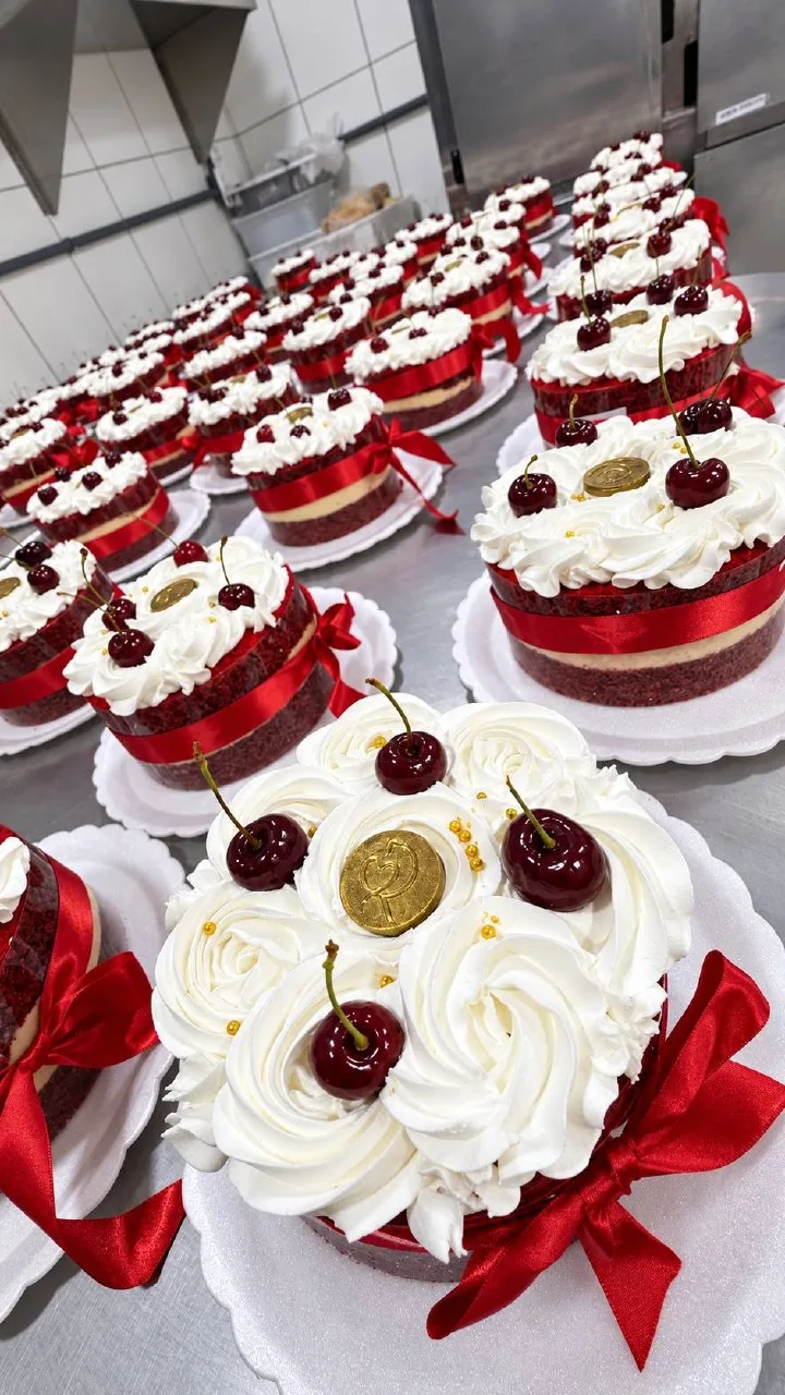 Dezenas de red velvets da Rôof enfileirados na produção de Natal, com laço vermelho e cerejas